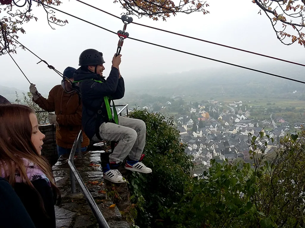 Jugendlicher hängt startbereit an der Seilrutsche.